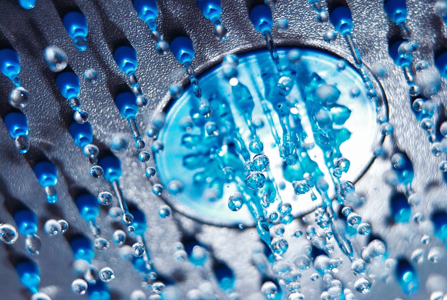 Nahaufnahme feuchter Duschkopf-Düsen mit Wassertropfen